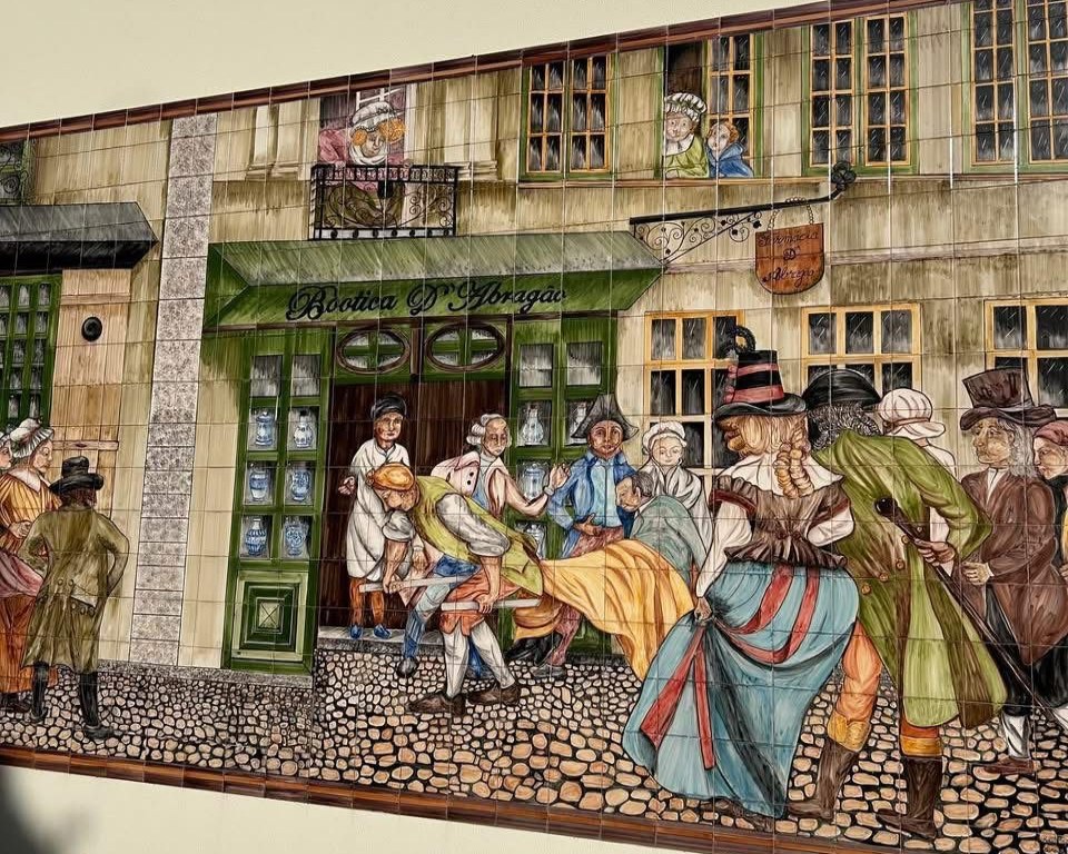 Painel de azulejos com a Bootica D'Abragão numa rua antiga
